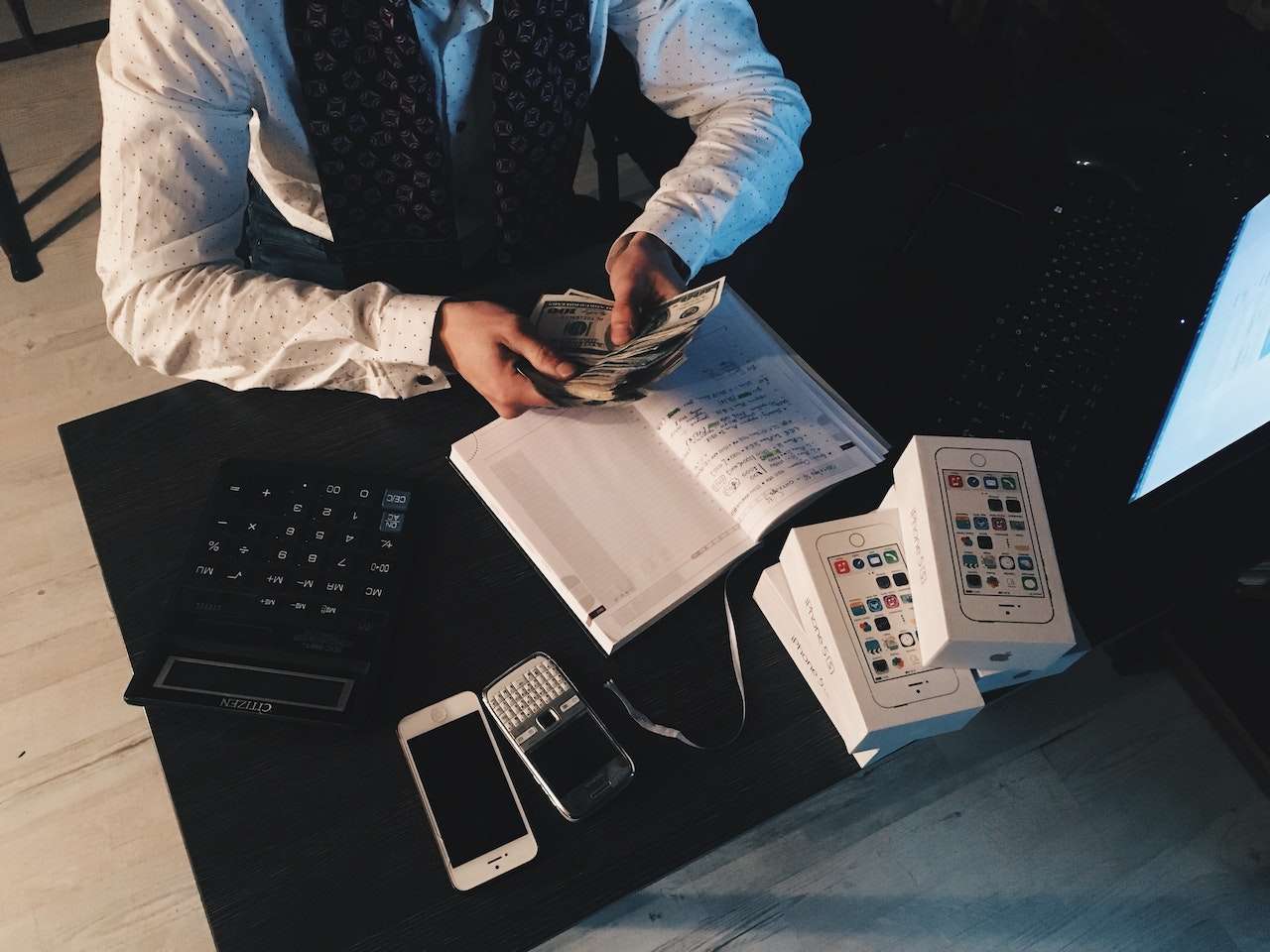 hands counting money in front of the office table making money online
